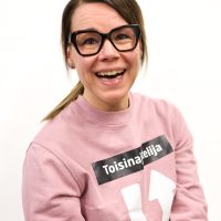 Iloinen Sanna hymyilee kuvassa.