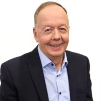 Kari hymyilee kameralle puku päällä.