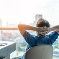 Kuvituskuva, jossa henkilö istumassa ikkunan ääressä.