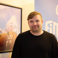 Fingersoftin toimitusjohtaja Jaakko Kylmäoja Fingersoft-logon edessä toimistolla.