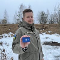 Yrittäjä Janne Nyyssönen esittelee Nato-hihamerkkiä.