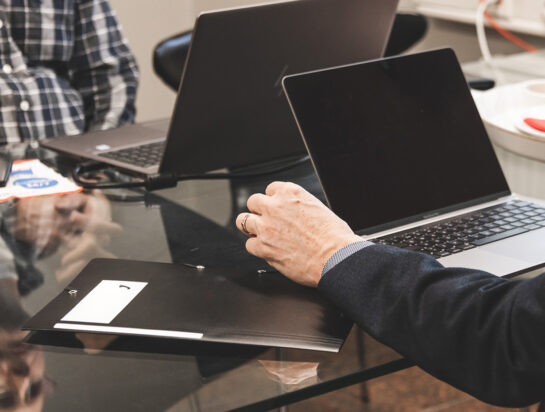 Kuvituskuva, kaksi henkilöä tietokoneen vieressä