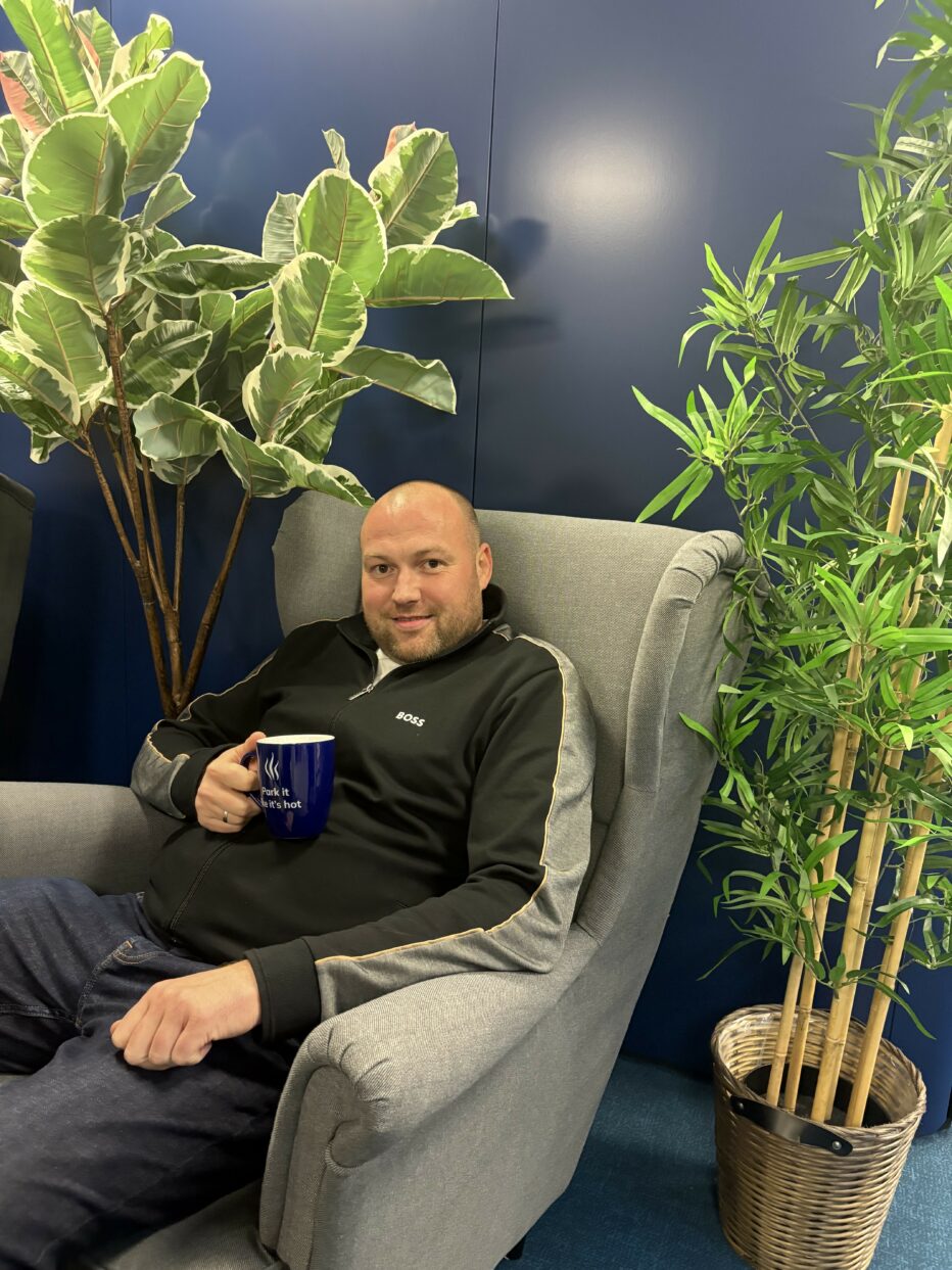 Alexander Ivaine istuu harmaassa nojatuolissa viherkasvien ympäröimänä