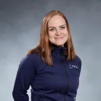 Emmi Satama hymyilee kameralle sinisessä paidassa.