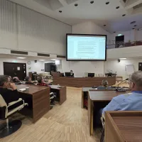 useita henkilöitä seuraa esitystä valtuustosalissa