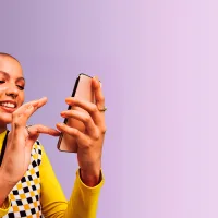 Nainen selaa puhelinta violetilla taustalla